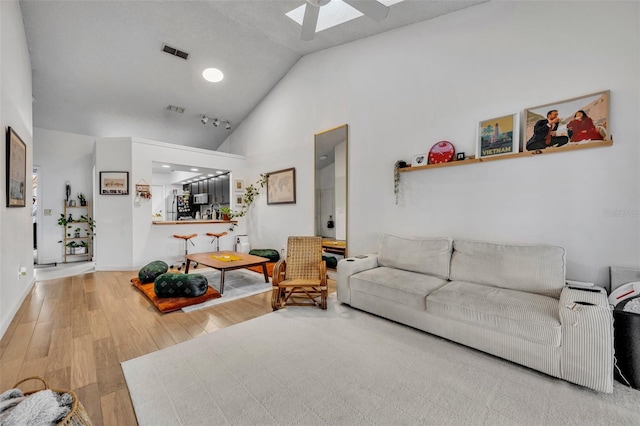 living room featuring hardwood / wood-style flooring, high vaulted ceiling, and ceiling fan