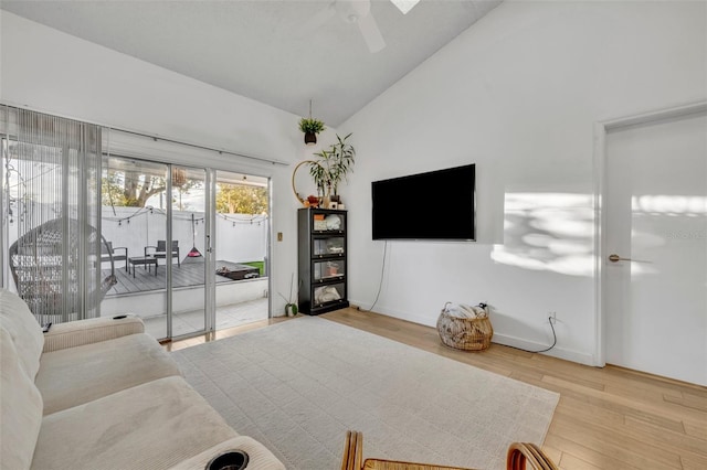 living room featuring ceiling fan, lofted ceiling, and wood-type flooring