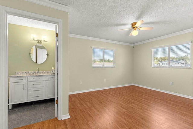 17664 SE 105th Ter, Summerfield, FL 34491 - unfurnished bedroom featuring wood finished floors, crown molding, a textured ceiling, baseboards, and bar with sink