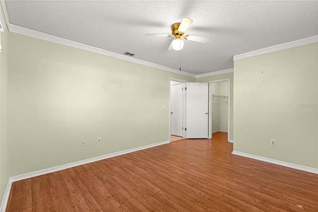 17664 SE 105th Ter, Summerfield, FL 34491 - unfurnished bedroom featuring a textured ceiling, wood finished floors, baseboards, crown molding, and a spacious closet