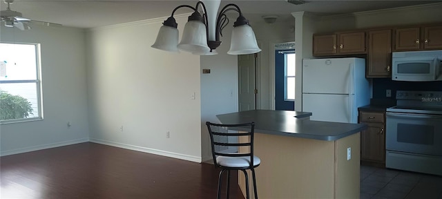 kitchen with crown molding, a center island, a wealth of natural light, and white appliances