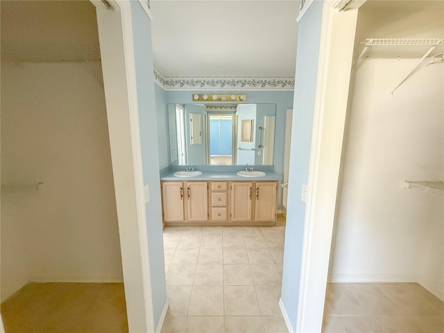 full bath with double vanity, a sink, and tile patterned floors