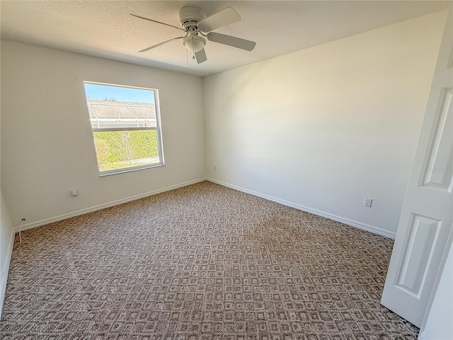 empty room with a ceiling fan, baseboards, dark colored carpet, and a textured ceiling