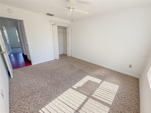 unfurnished bedroom with a closet, visible vents, carpet flooring, ceiling fan, and baseboards