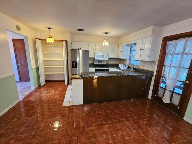 kitchen featuring sink, backsplash, hanging light fixtures, stainless steel appliances, and kitchen peninsula