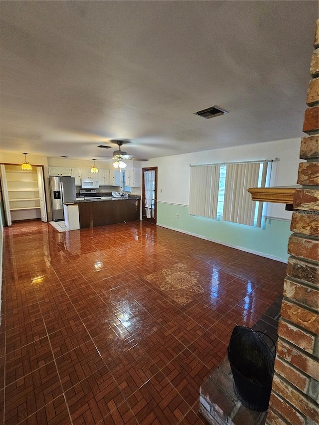 unfurnished living room featuring ceiling fan