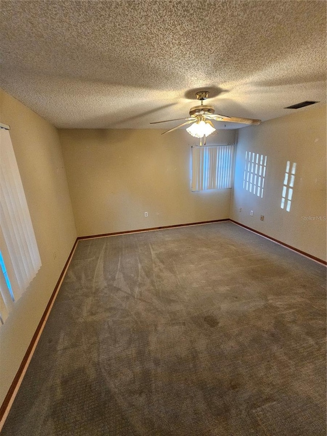 unfurnished room featuring ceiling fan, carpet floors, and a textured ceiling