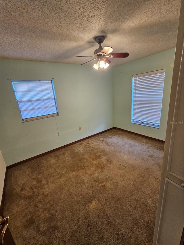 empty room featuring ceiling fan, carpet flooring, and a textured ceiling