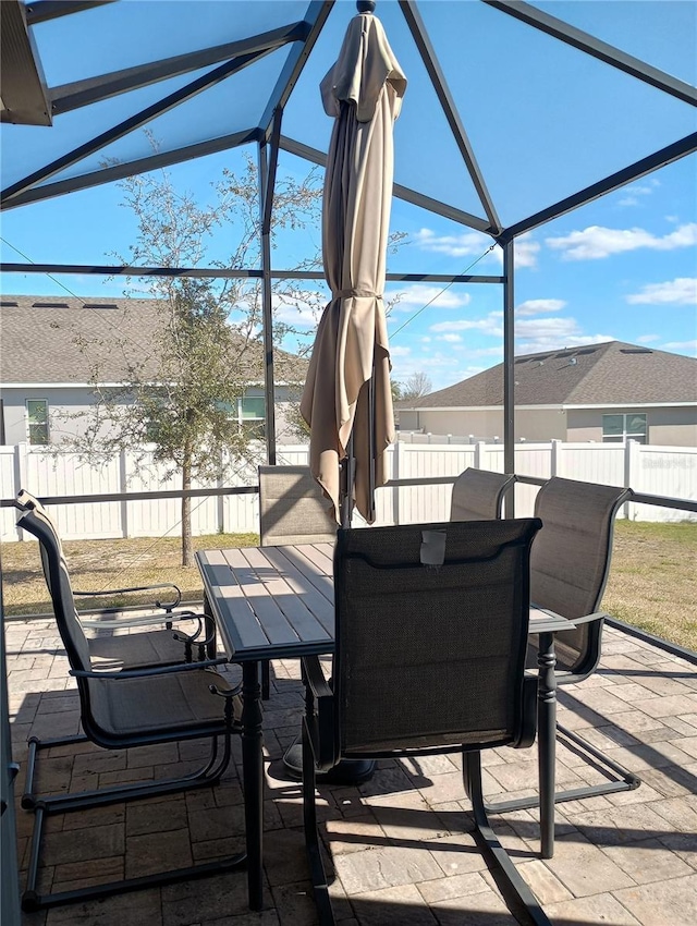 view of patio with a water view and a lanai