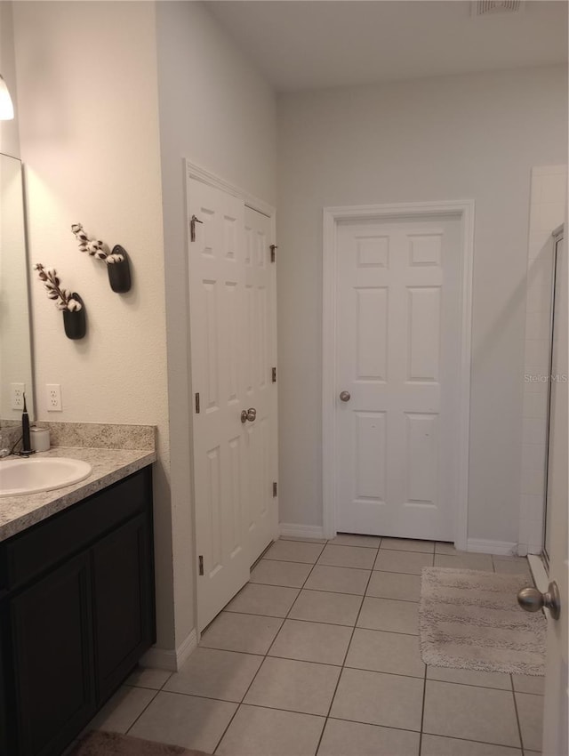 bathroom with vanity, a shower with door, and tile patterned flooring