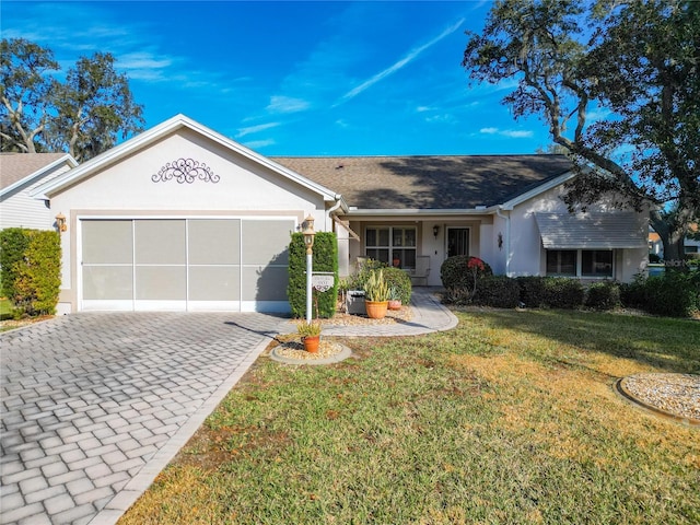 ranch-style house featuring a garage and a front lawn