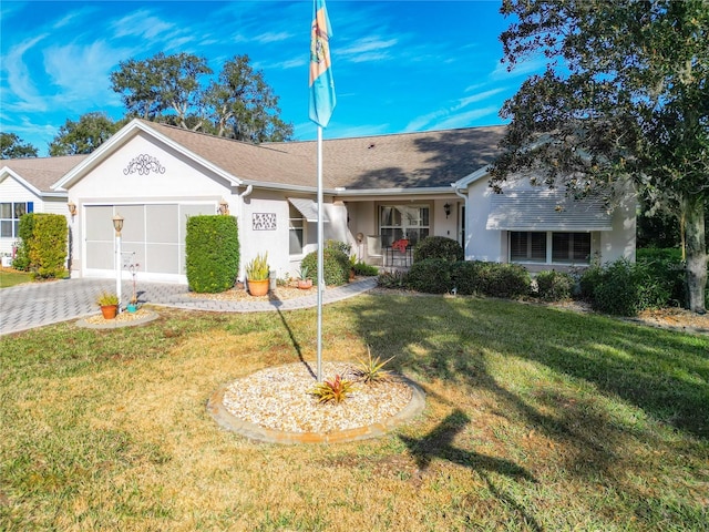 single story home with a porch, a garage, and a front yard