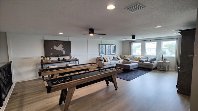 playroom featuring hardwood / wood-style flooring, ceiling fan, and a textured ceiling