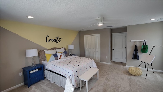 bedroom with ceiling fan, light colored carpet, a closet, and a textured ceiling