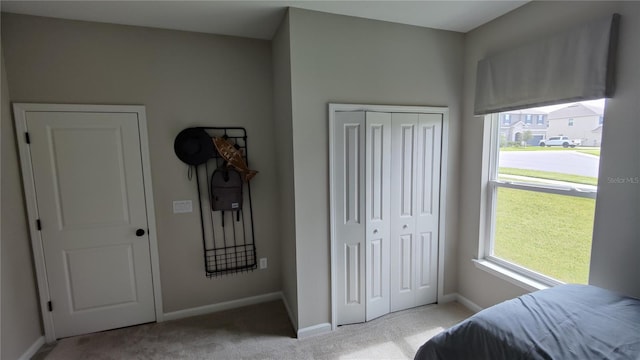 bedroom featuring light colored carpet and a closet