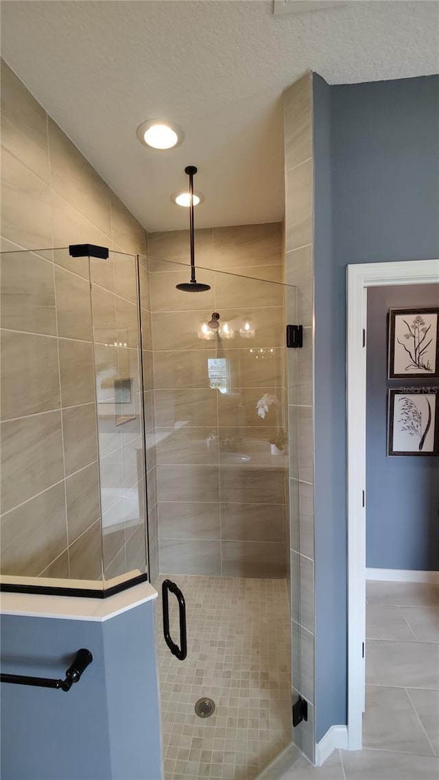 bathroom featuring tile patterned floors, a shower with shower door, and a textured ceiling