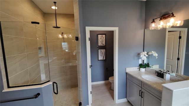 bathroom featuring vanity, toilet, tile patterned flooring, and a shower with door