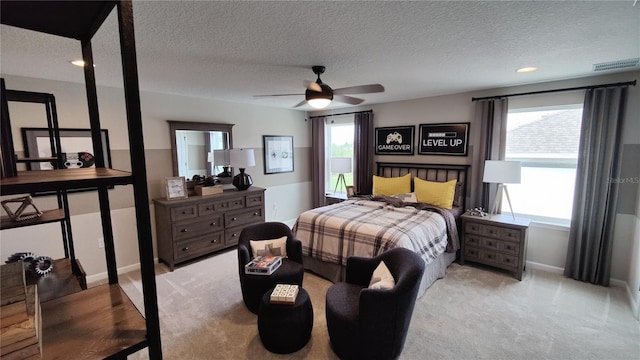 bedroom featuring light carpet, a textured ceiling, and ceiling fan