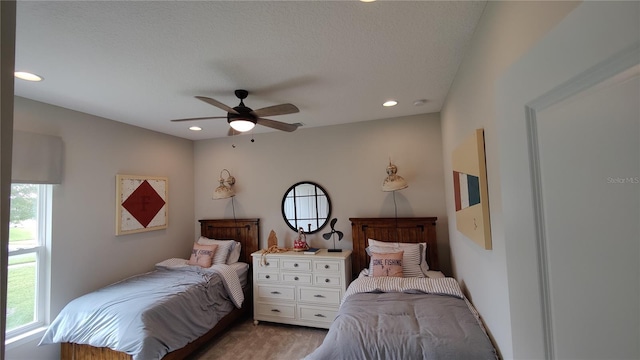 carpeted bedroom with a textured ceiling and ceiling fan