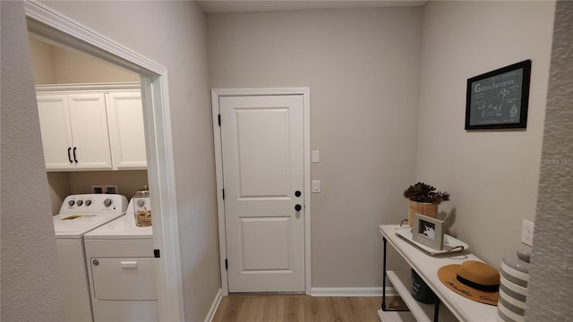 laundry room featuring cabinets, washer and dryer, and light wood-type flooring