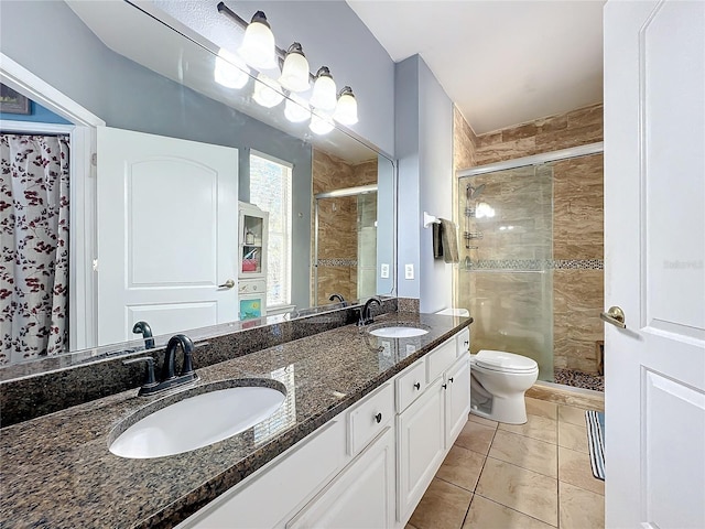 bathroom featuring vanity, tile patterned flooring, a shower with shower door, and toilet