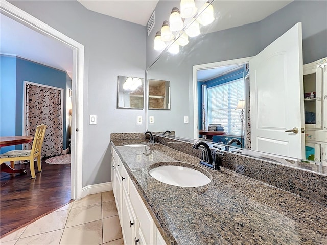 bathroom with tile patterned flooring, vanity, and a chandelier