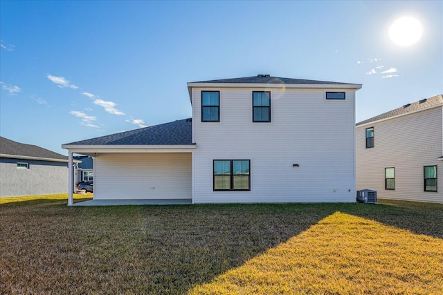 rear view of house with cooling unit, a patio area, and a lawn