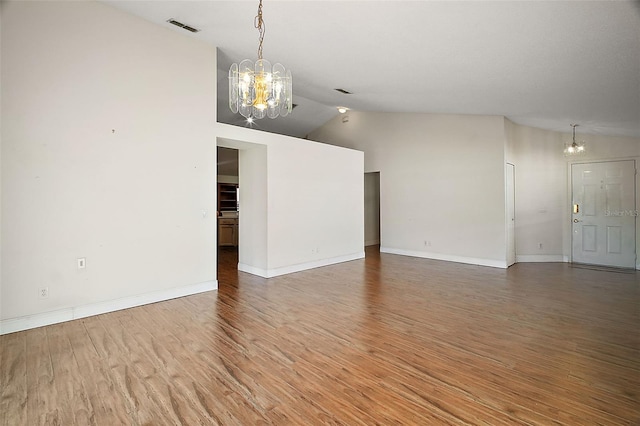 unfurnished room featuring hardwood / wood-style flooring, high vaulted ceiling, and an inviting chandelier