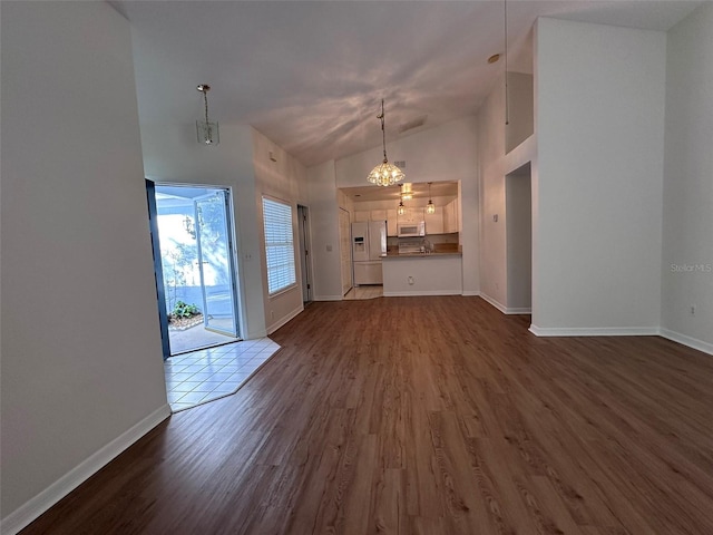 unfurnished living room featuring dark hardwood / wood-style floors and high vaulted ceiling