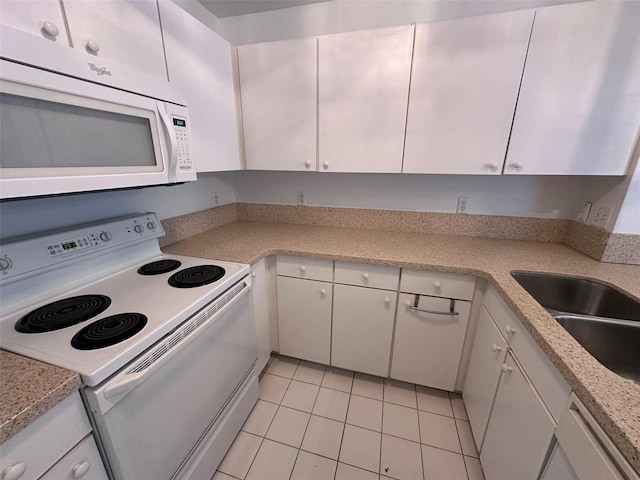 kitchen with sink, white appliances, light tile patterned floors, light stone counters, and white cabinets