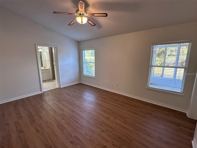 unfurnished room with dark hardwood / wood-style flooring, a textured ceiling, lofted ceiling, and ceiling fan