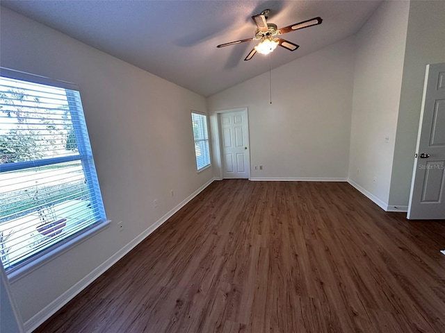 empty room with vaulted ceiling, ceiling fan, and dark hardwood / wood-style flooring