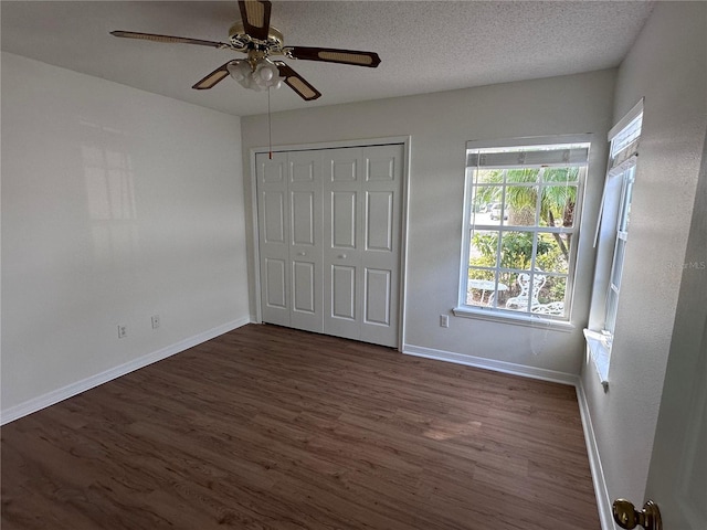 unfurnished bedroom featuring ceiling fan, dark hardwood / wood-style flooring, and a textured ceiling