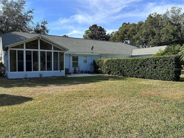 back of house featuring a sunroom and a lawn