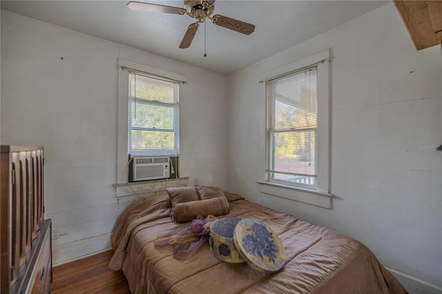 bedroom featuring cooling unit, hardwood / wood-style floors, and ceiling fan