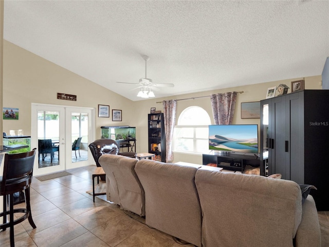 tiled living room featuring lofted ceiling, a wealth of natural light, french doors, and a textured ceiling