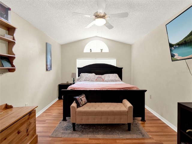 bedroom featuring vaulted ceiling, ceiling fan, hardwood / wood-style floors, and a textured ceiling