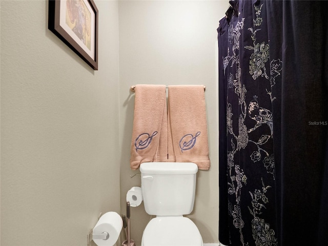 bathroom featuring curtained shower and toilet