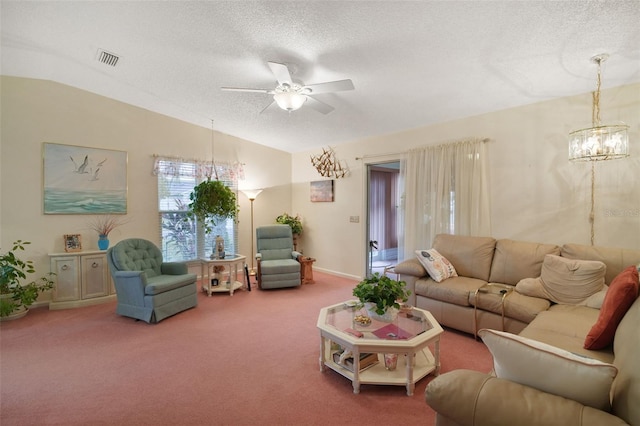 living room featuring ceiling fan with notable chandelier, vaulted ceiling, a textured ceiling, and carpet