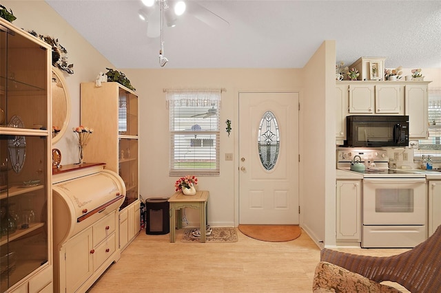 interior space with ceiling fan, electric range, light hardwood / wood-style flooring, and white cabinets