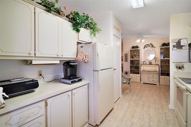 kitchen with white cabinets, white appliances, ceiling fan, a textured ceiling, and light wood-type flooring