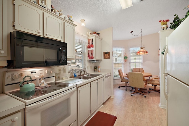 kitchen featuring sink, white appliances, a textured ceiling, decorative light fixtures, and light wood-type flooring