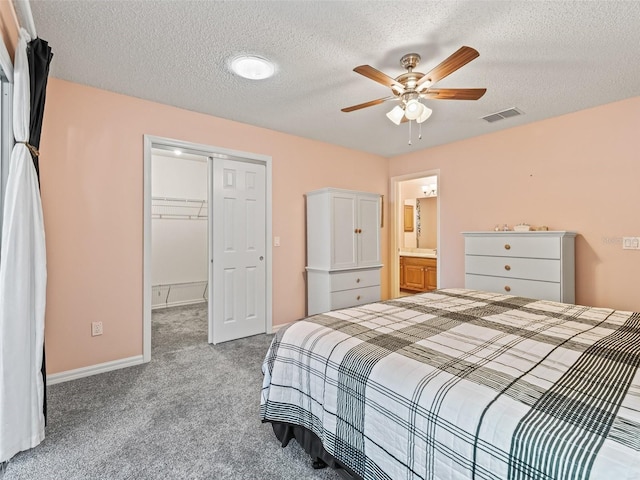 carpeted bedroom with ceiling fan, a closet, and a textured ceiling