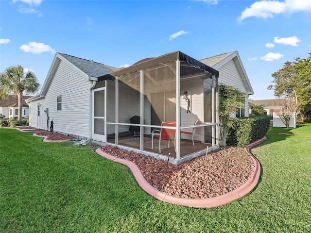 view of side of home with a sunroom and a lawn