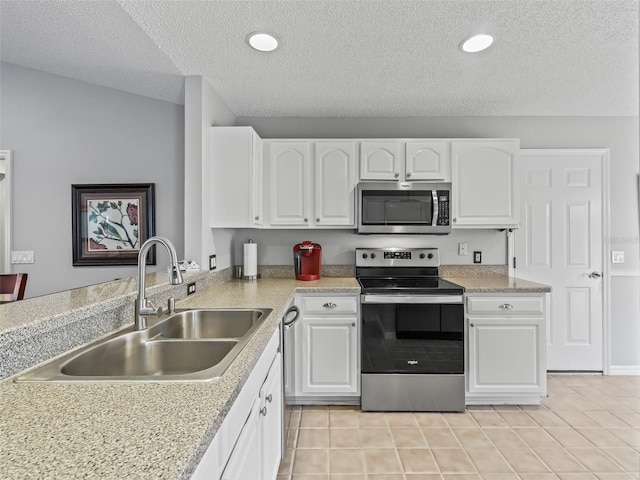 kitchen with stainless steel appliances, light tile patterned flooring, sink, and white cabinets