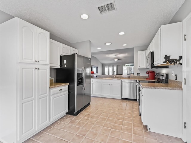 kitchen featuring sink, white cabinetry, light tile patterned floors, ceiling fan, and stainless steel appliances