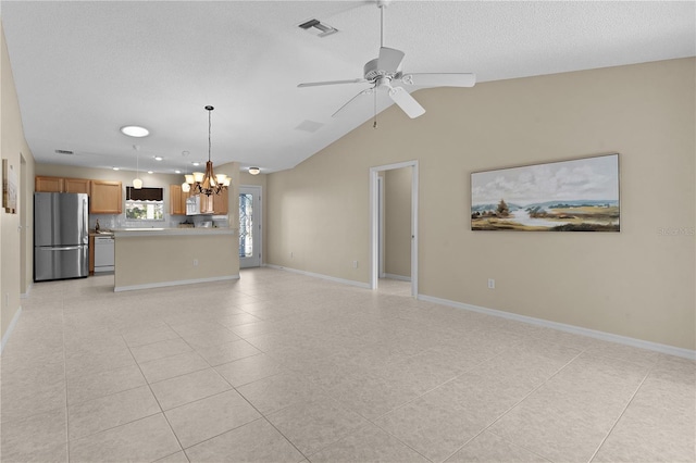 unfurnished living room featuring ceiling fan with notable chandelier, vaulted ceiling, a textured ceiling, and light tile patterned flooring