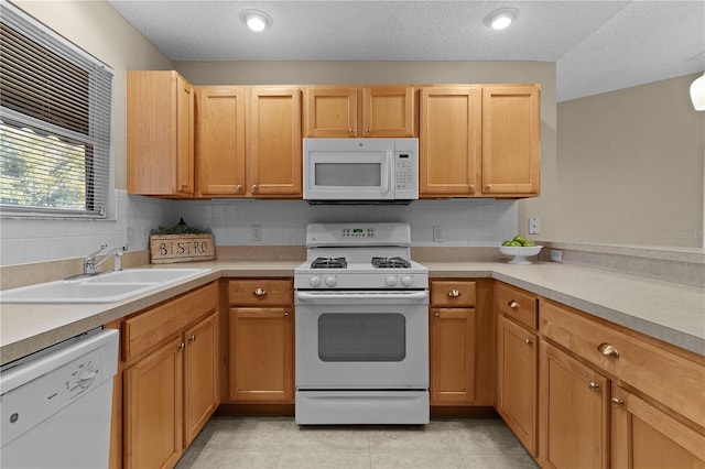 kitchen with sink, white appliances, decorative backsplash, and light tile patterned flooring