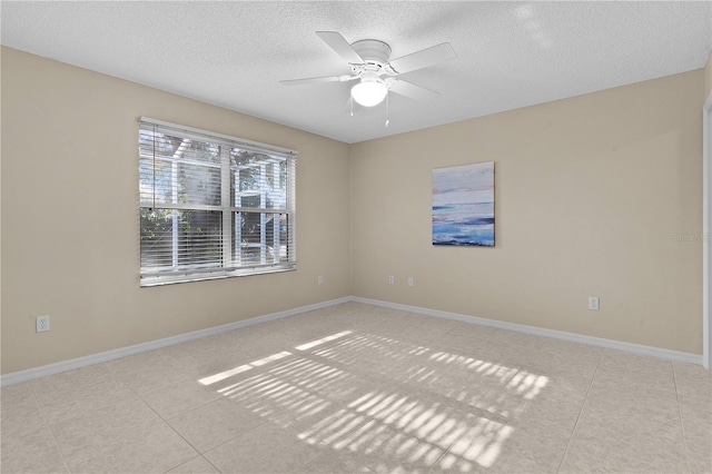 tiled spare room featuring ceiling fan and a textured ceiling