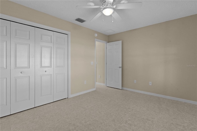 unfurnished bedroom with a textured ceiling, ceiling fan, and a closet